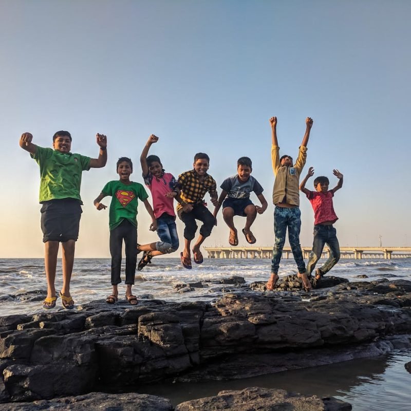 indian children jumping in joy, playing around the sea shore